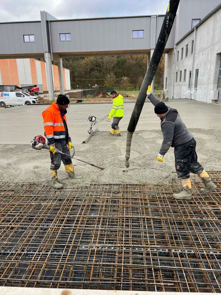 Eine Gruppe Bauarbeiter arbeitet an einem Betonboden.