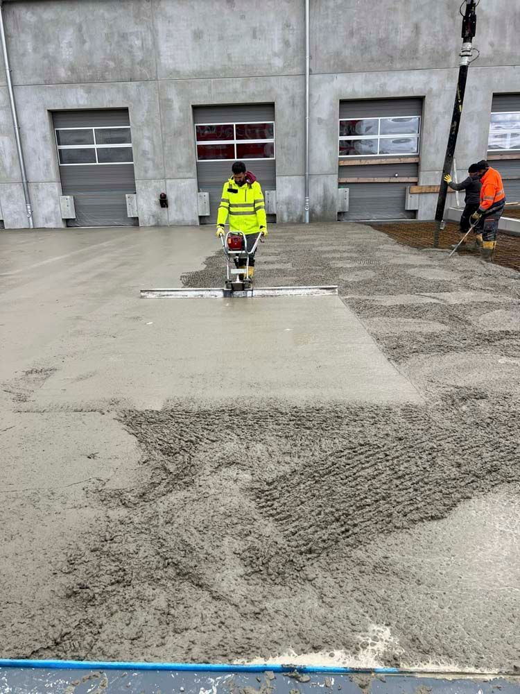 Ein Mann in einer gelben Jacke läuft auf einer Betonfläche.