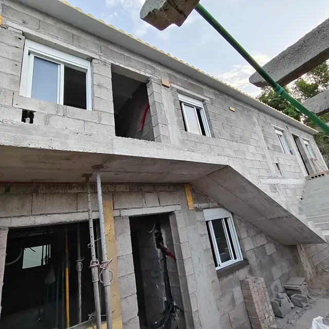 Un edificio en construcción con escaleras que suben al segundo piso.