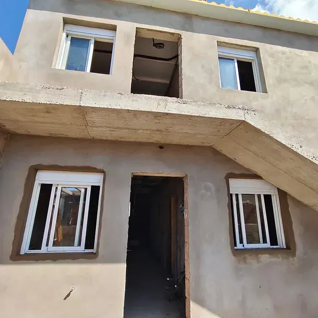 El frente de un edificio con escaleras que conducen al segundo piso.