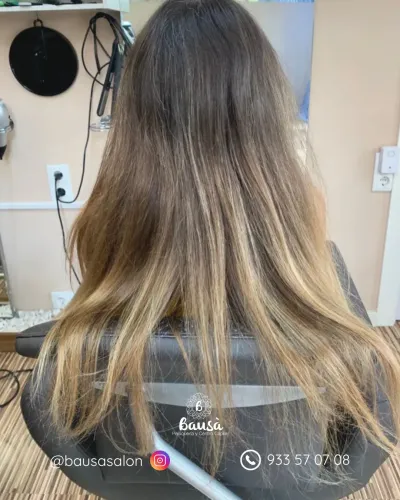 Vista trasera de una persona con cabello largo y castaño que empieza a aclararse con mechas rubias.
