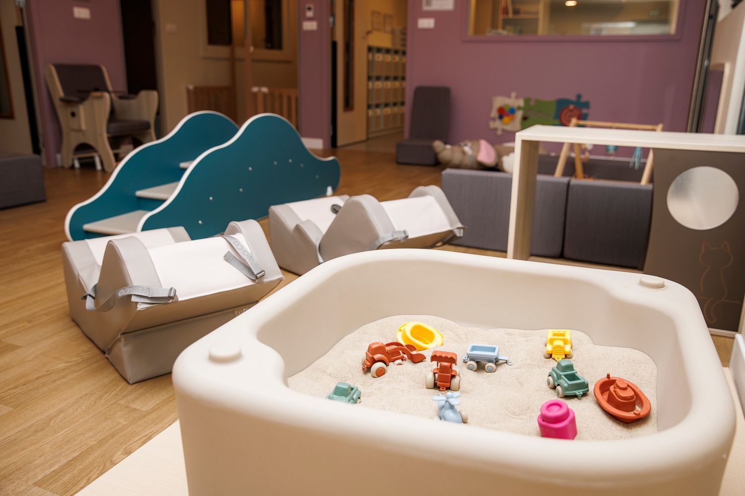 Pièce d'activité de la crèche avec un bac à sable intérieur.