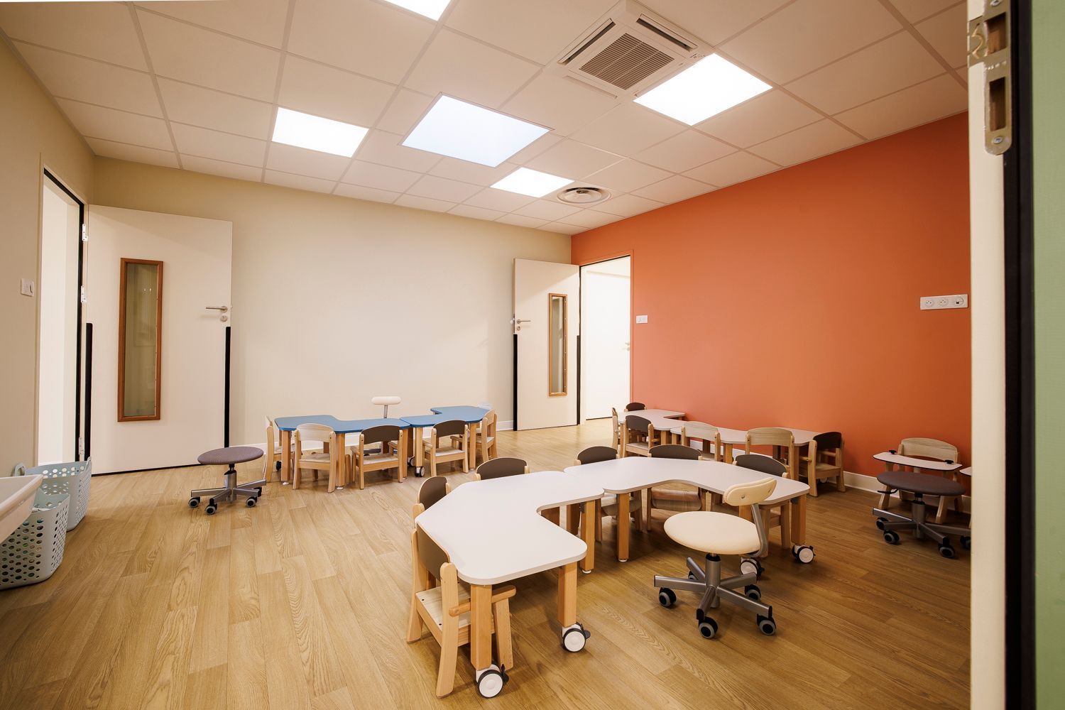 Photo d'une pièce d'activité avec des chaises et des tables de la crèche.