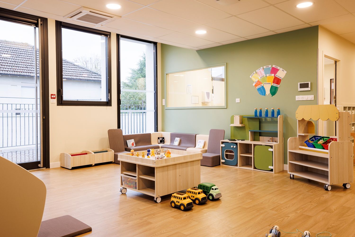 Pièce de jeux de la crèche avec des petits fauteuils et canapés en mousses de couleurs.