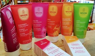 Cinco tubos de colores y dos cajas de productos para el cuidado de la piel de la marca Weleda.