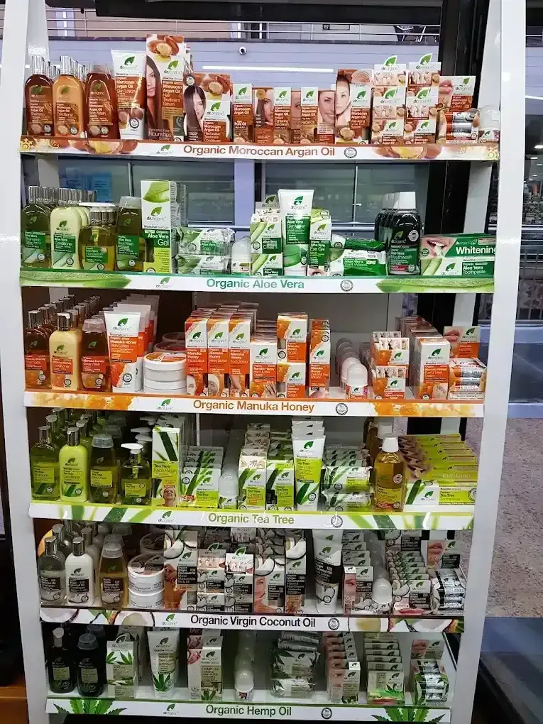 Un estante de exhibición en una tienda, repleto de botellas y envases de diversos productos orgánicos.