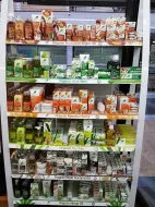 Un estante de exhibición en una tienda, repleto de botellas y envases de diversos productos orgánicos.