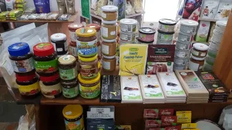 Estantería de la tienda repleta de tarros de mantequilla de frutos secos, recipientes.