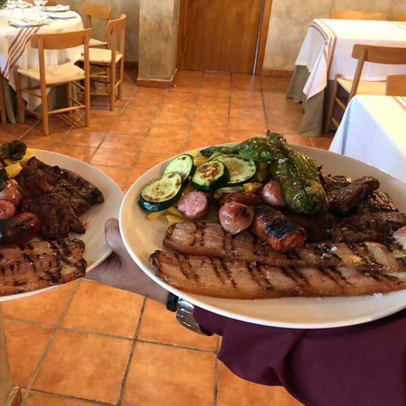 Una persona sostiene dos platos de comida en un restaurante.