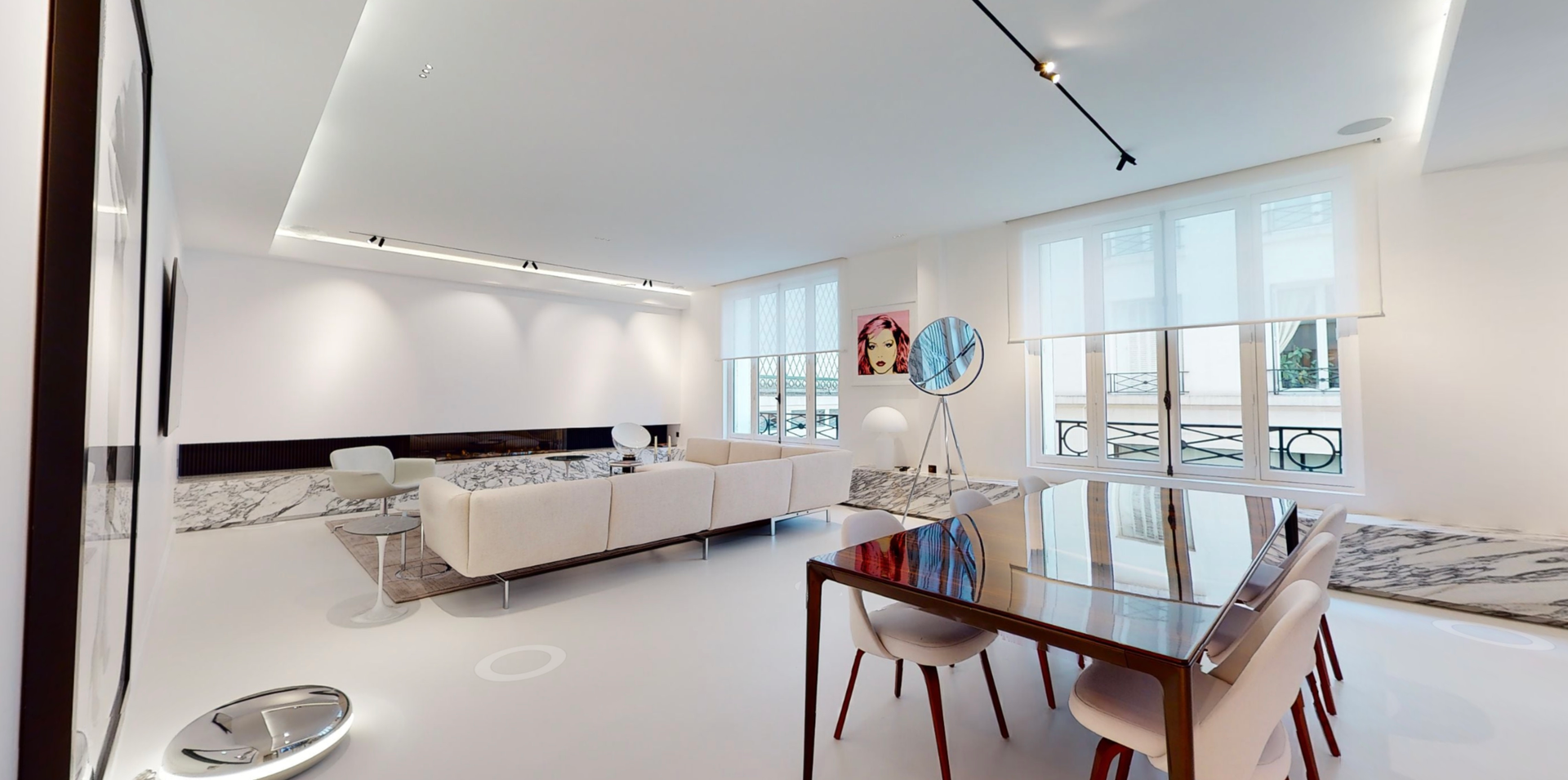 Salon d'un loft avec un revêtement en époxy effet marbre sous les fenêtres