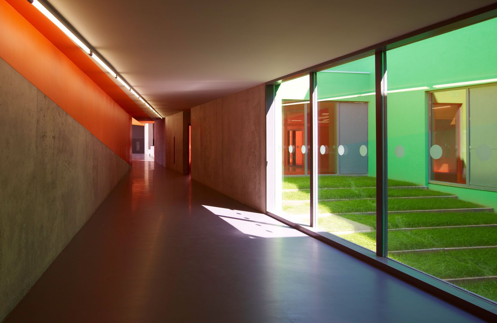 Couloir d'un bâtiment en béton ciré avec une grande véranda