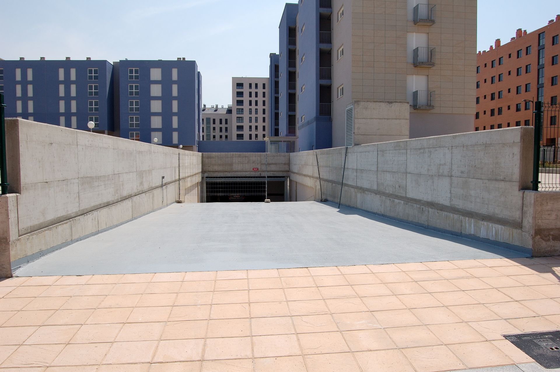 Un edificio con muchas ventanas está rodeado de otros edificios.