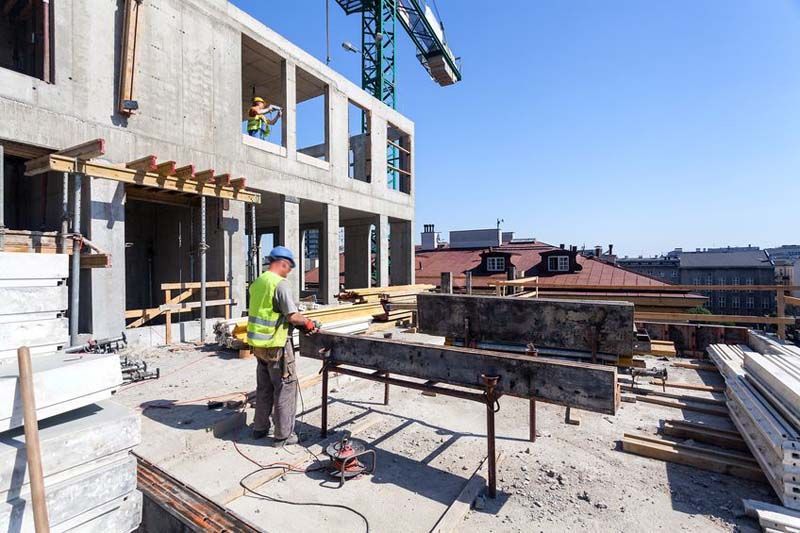 Un trabajador de la construcción está trabajando en el tejado de un edificio en construcción.