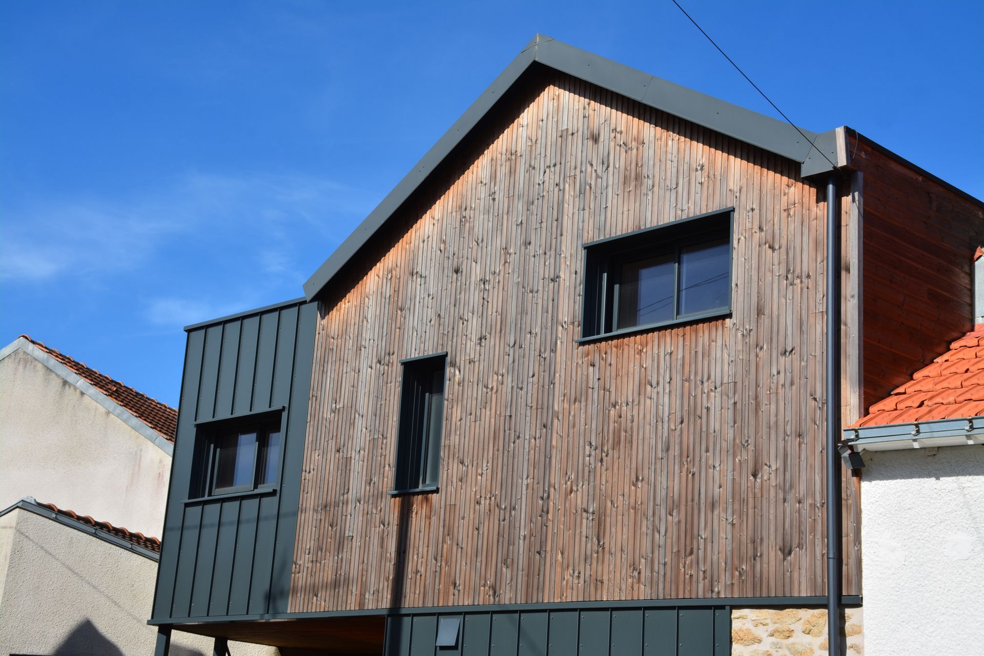 Extérieur d'une maison moderne à deux étages avec un toit à pignon.