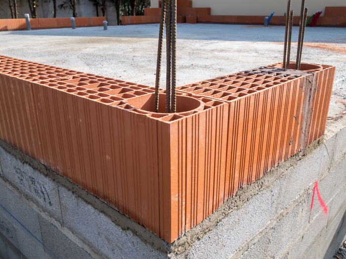 L’angle d'un mur en brique rouge en construction.