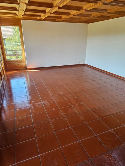 Betonstufen, die in einen grasbewachsenen Hang gebaut sind, führen nach oben. Grauer Stein, unebene Kanten.