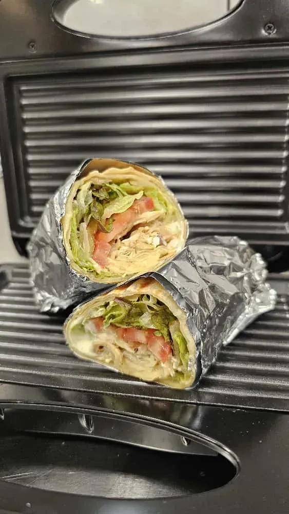 Wrap a la parrilla, cortado por la mitad, envuelto en papel aluminio y colocado sobre una parrilla.