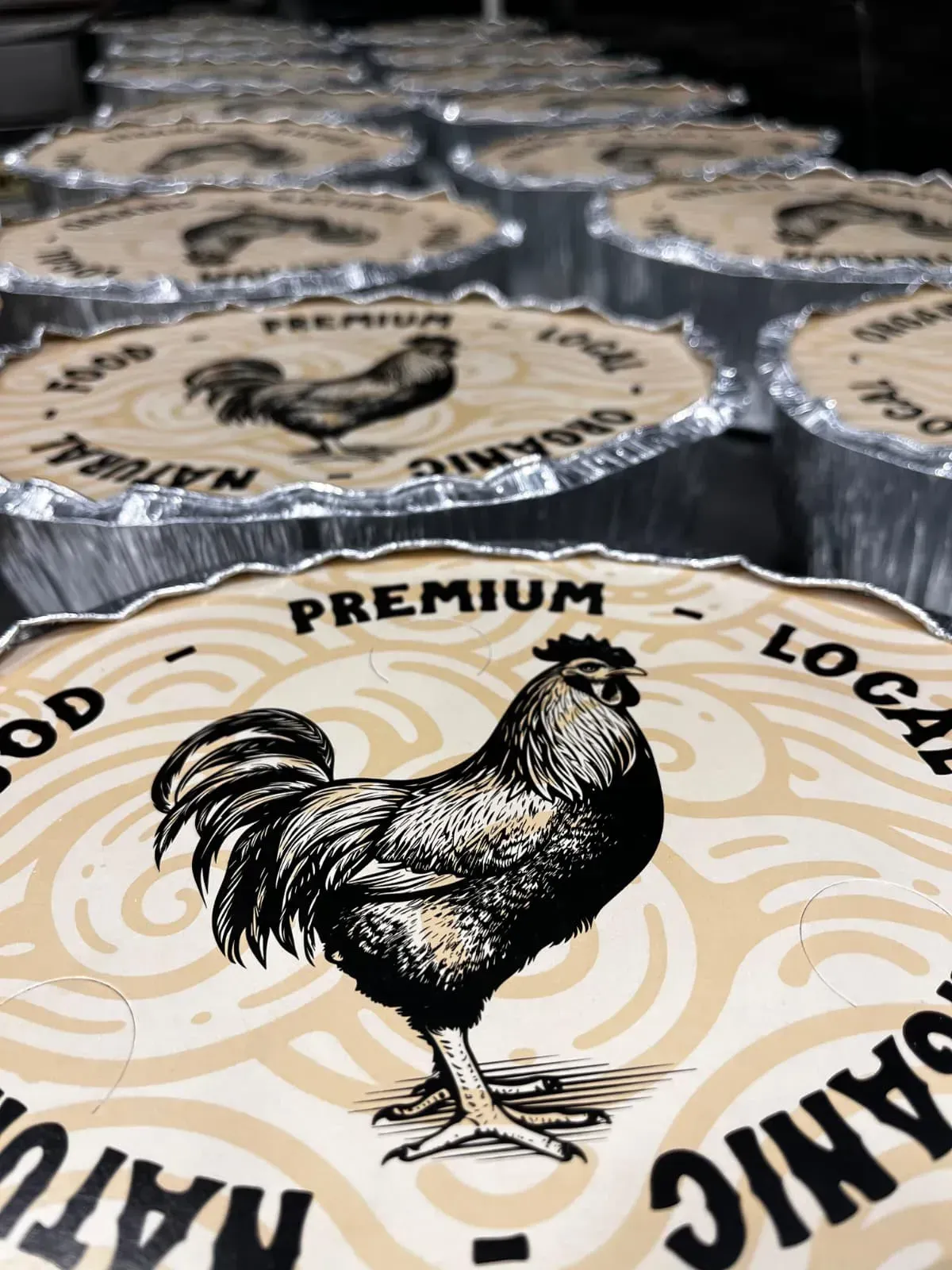 Recipientes para alimentos redondos con tapas que presentan un gráfico de gallo y la etiqueta