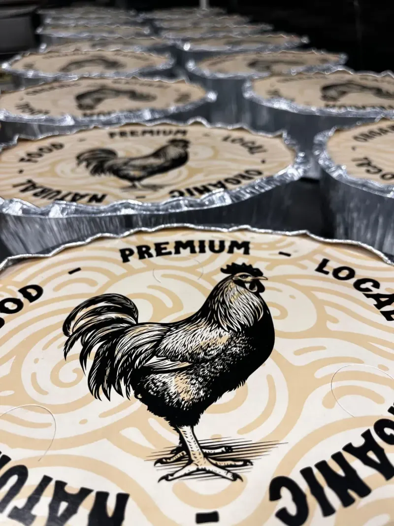 Recipientes para alimentos redondos con tapas que presentan un gráfico de gallo y la etiqueta