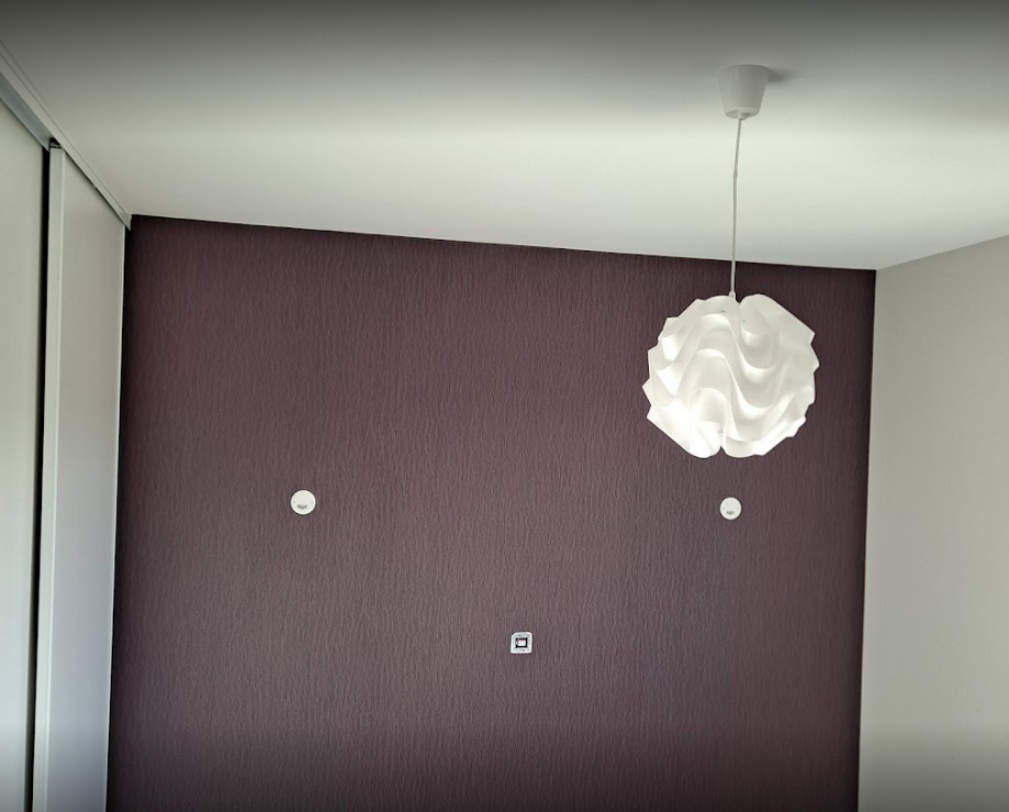 Papier peint texturé de type toile de verre dans un salon, vue sur luminaire