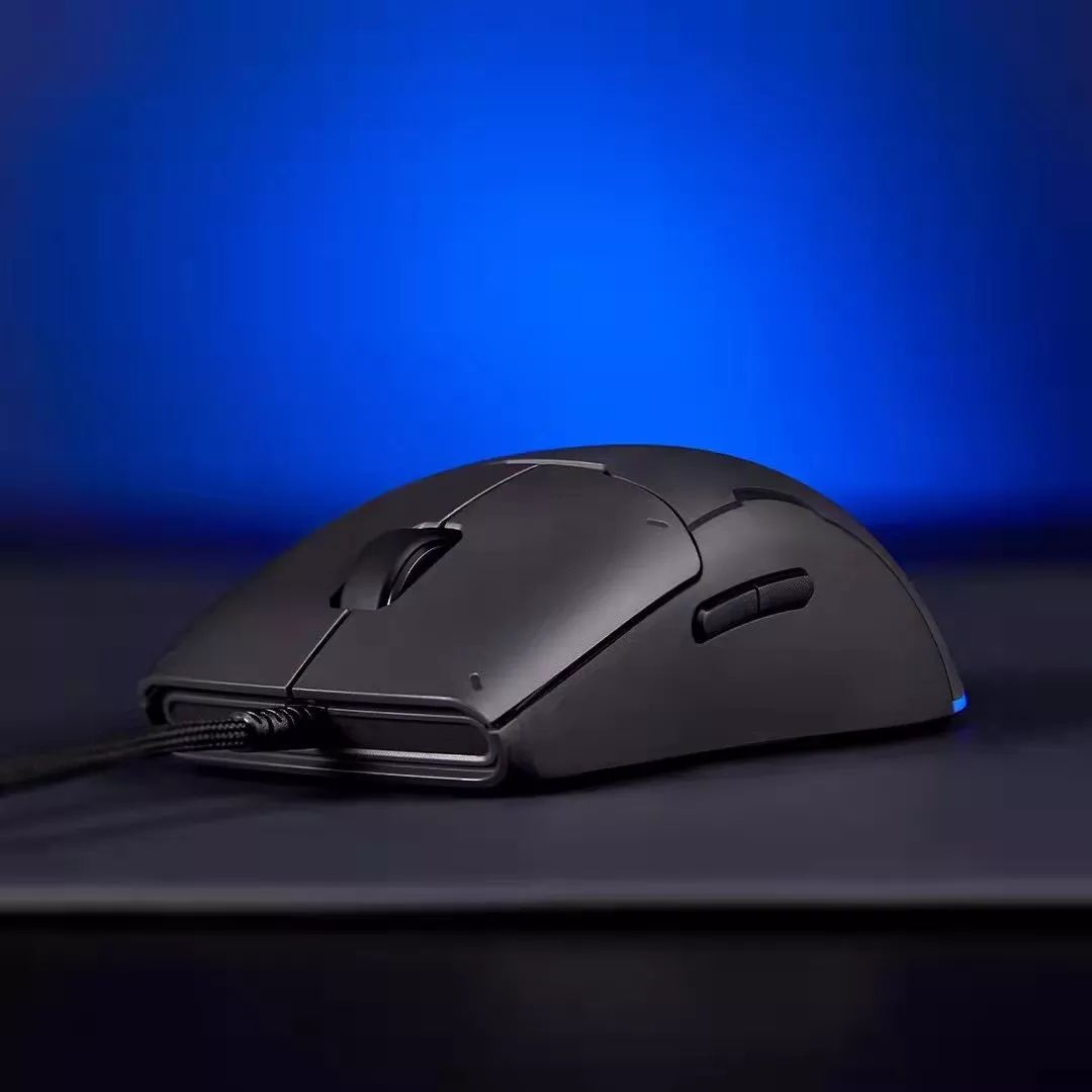 A black computer mouse is sitting on top of a black table.