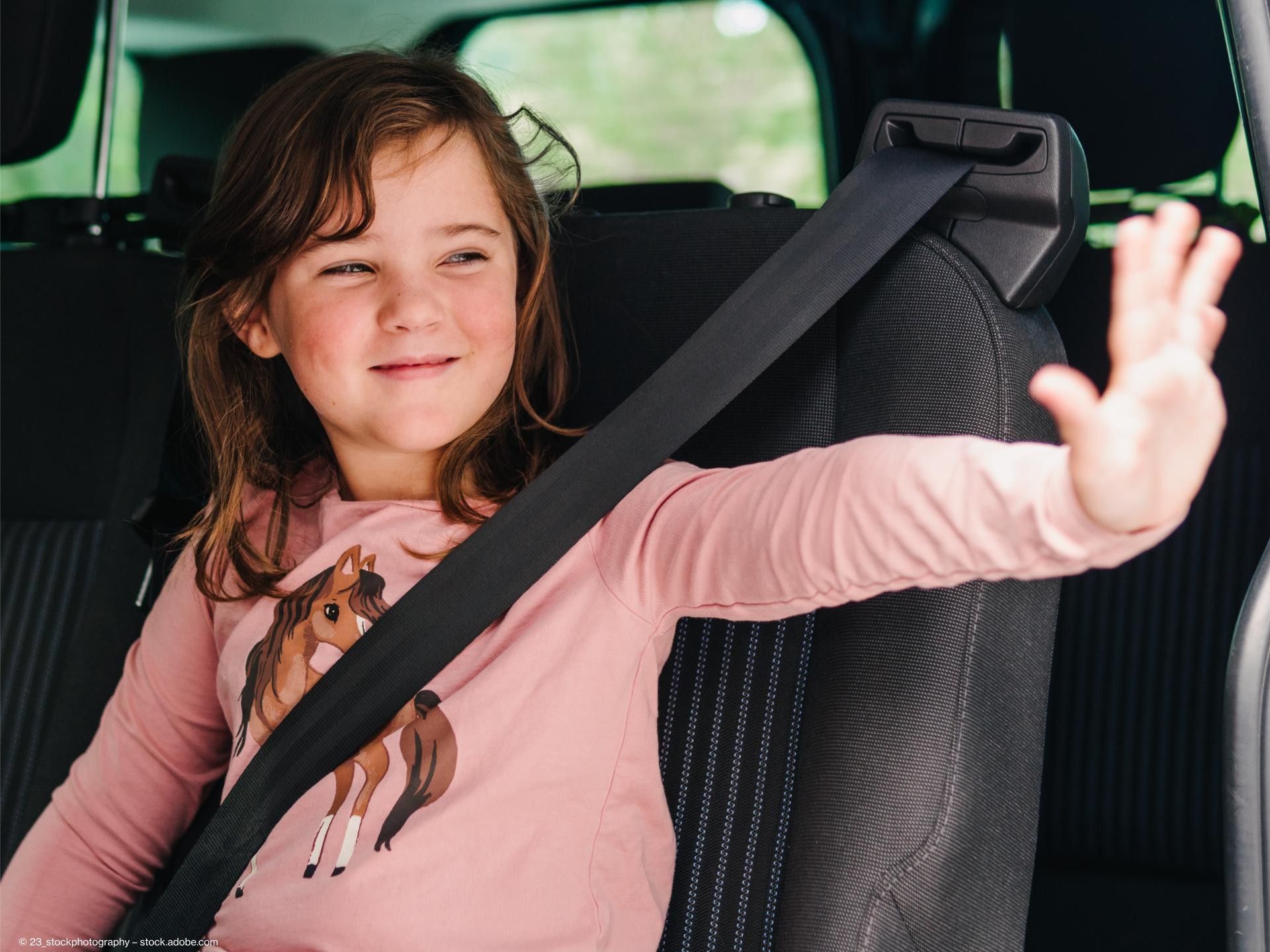 Kind sitzt auf der Rücksitzbank eines Taxis