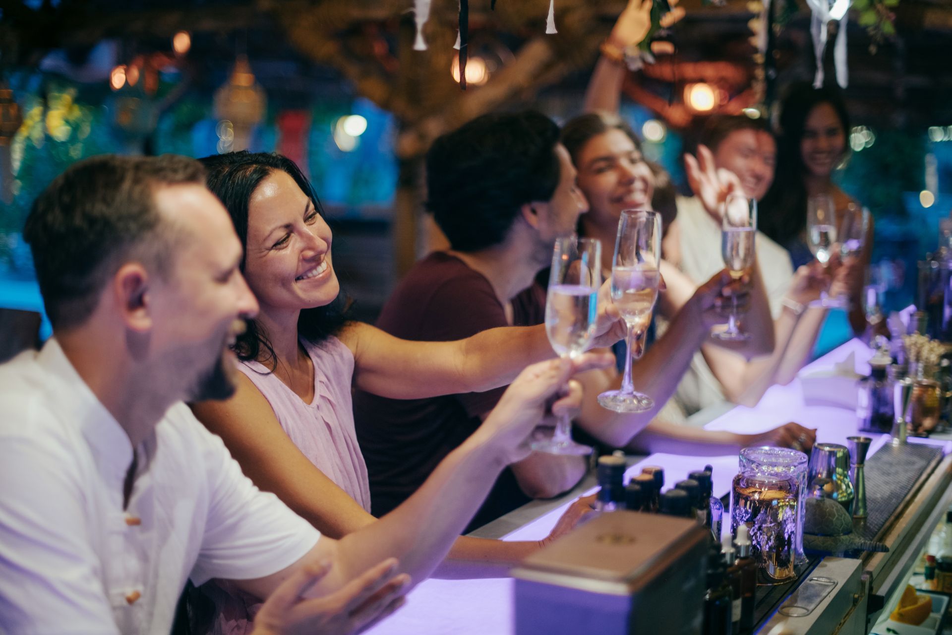 Des amis trinquent à un bar animé en plein air la nuit