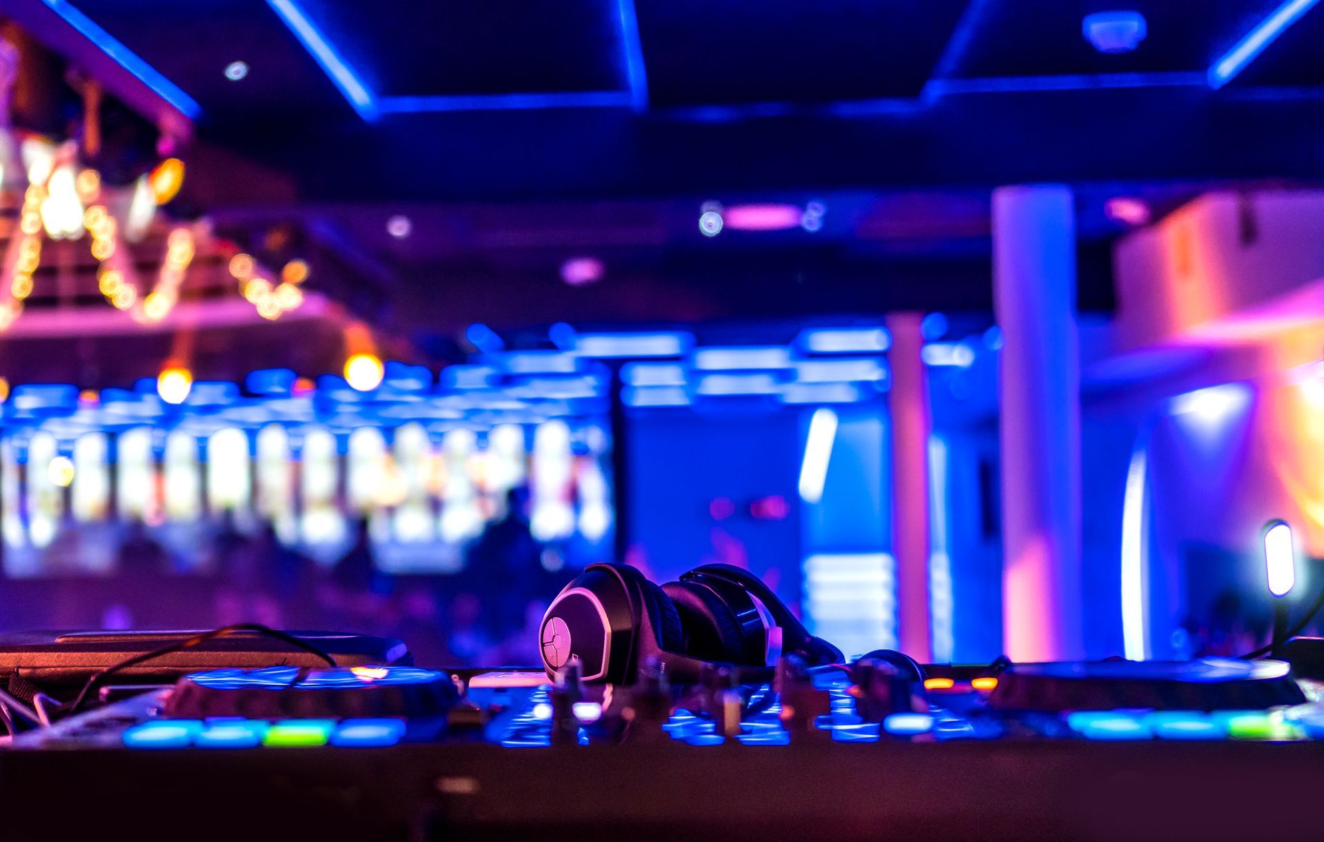 Cabine de DJ floue éclairée au néon, avec casque et lumières de club colorées