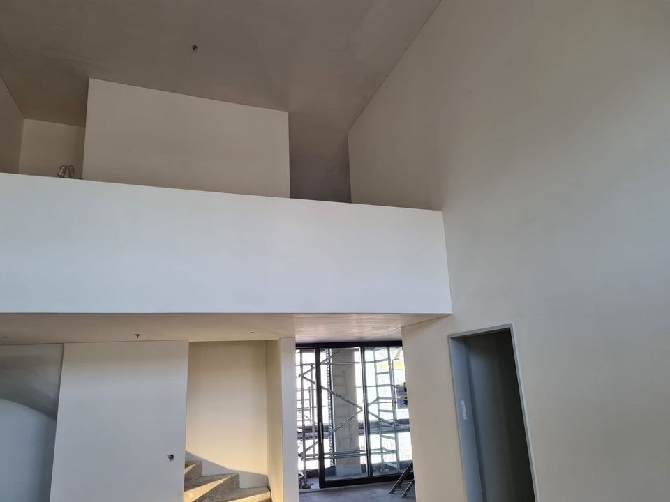 Ein Zimmer mit Balkon und Treppe. Foto von der Vini-Bau GmbH.