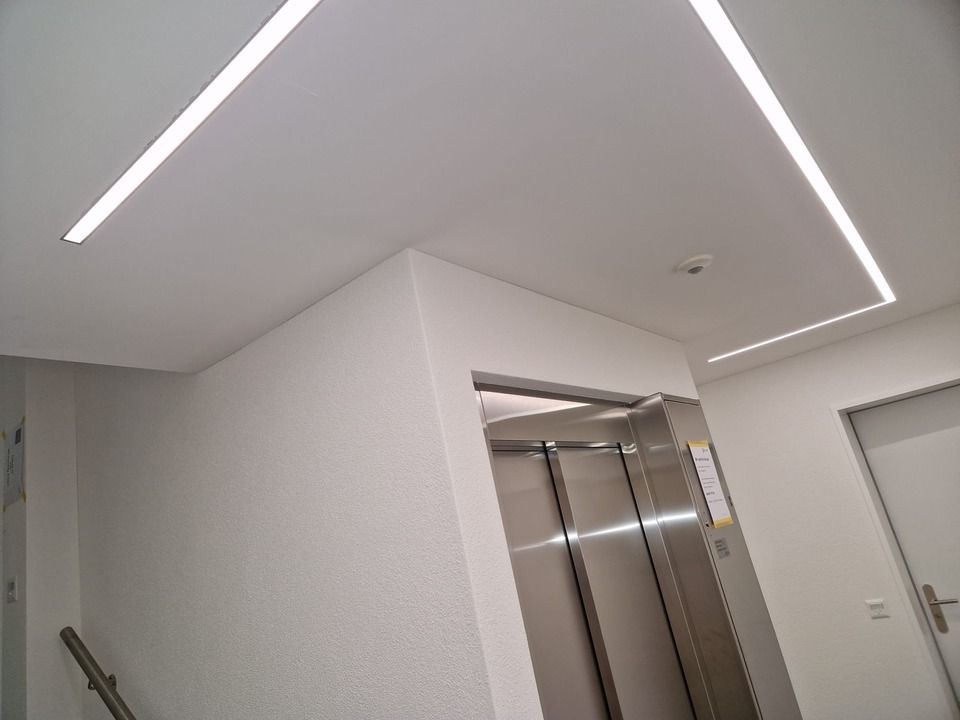 Ein Flur mit einer Treppe und einem Aufzug darin. Foto von der Vini-Bau GmbH.