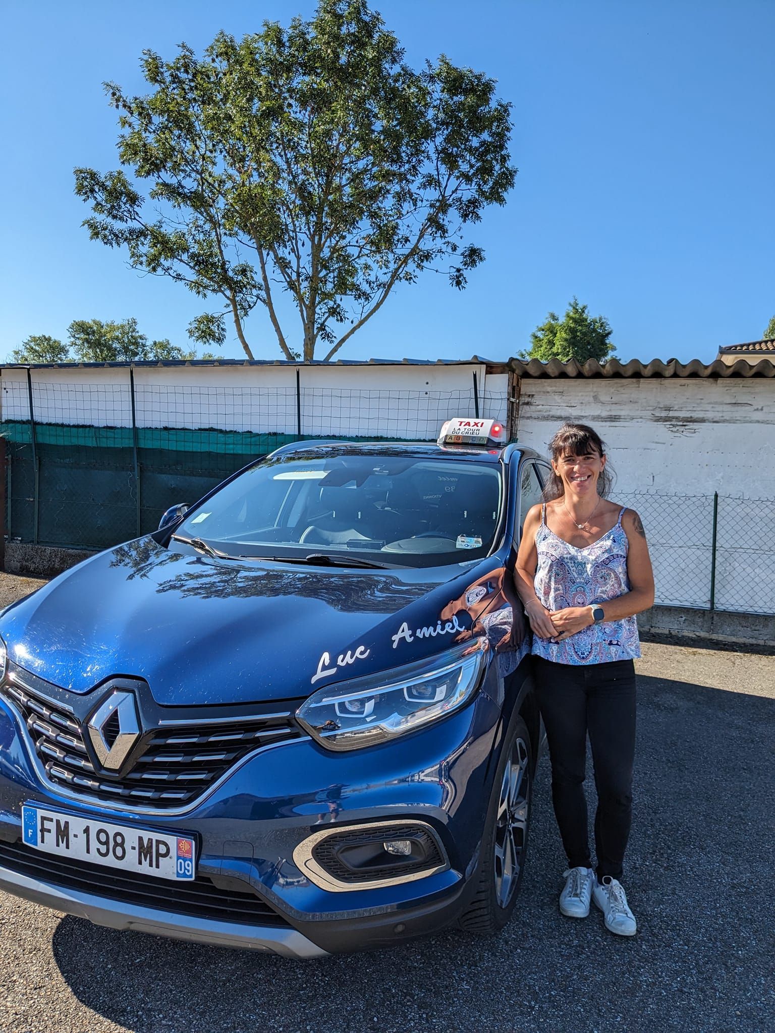 Chauffeuse à côté d'une voiture noire