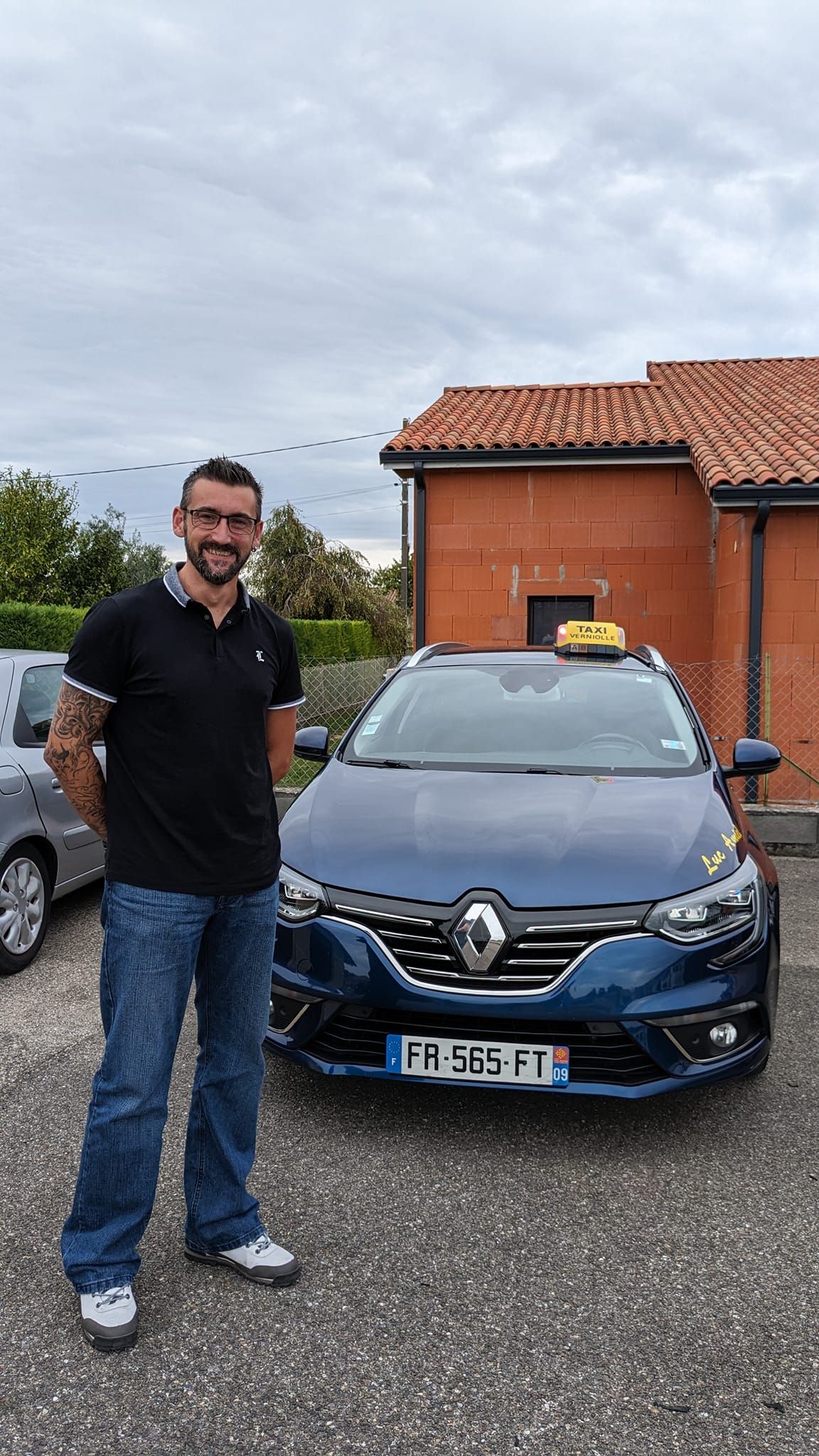 Chauffeur à côté d'une voiture bleue