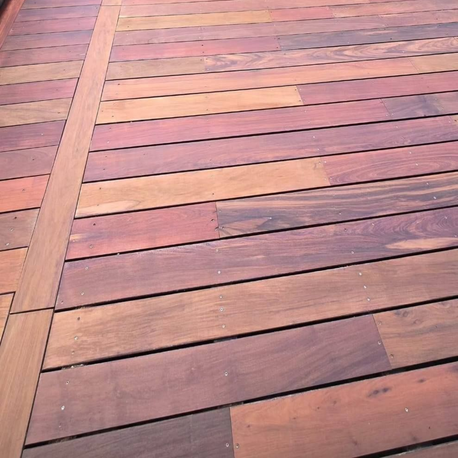 Un plancher de terrasse en bois composé de planches horizontales et de teintes variées.