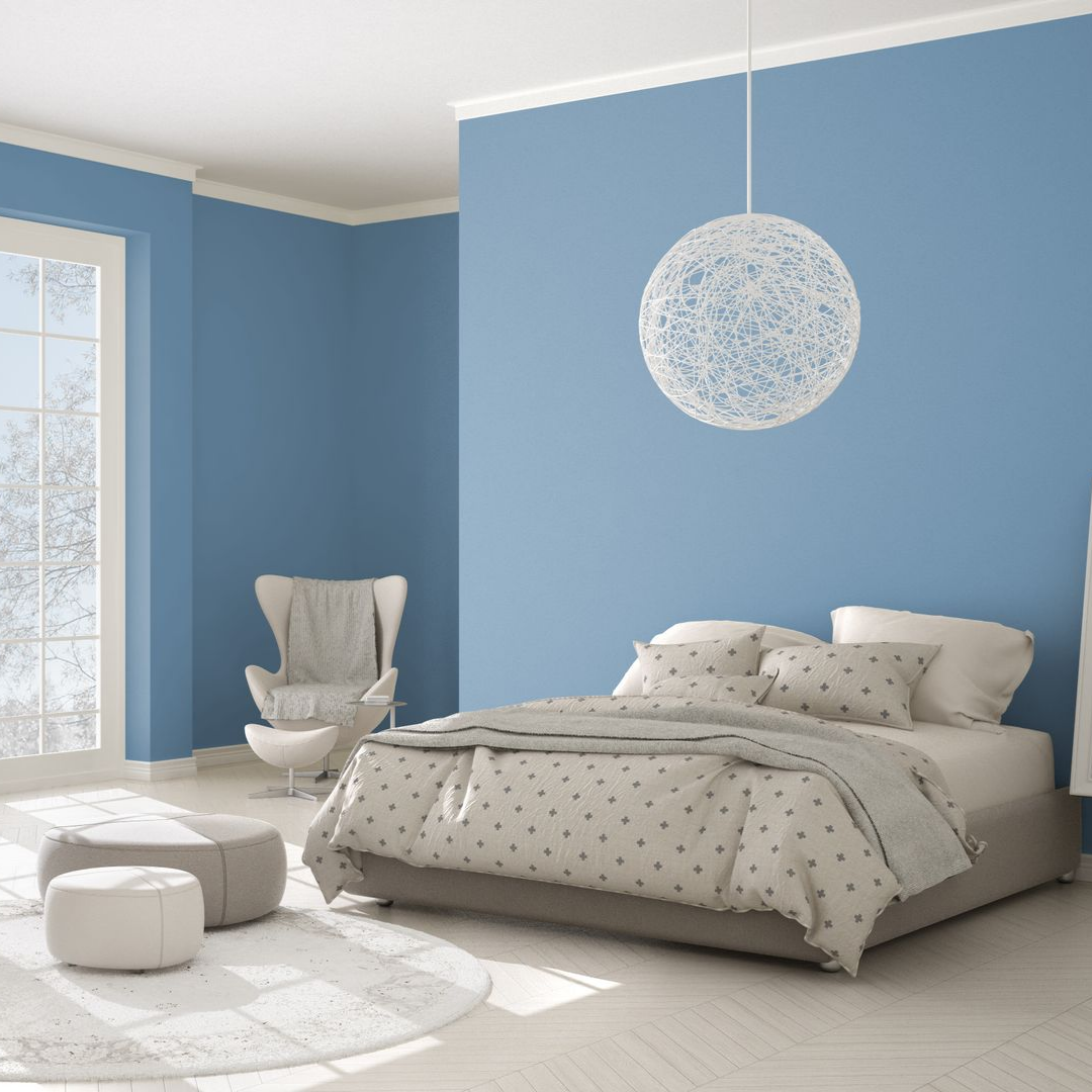 Chambre avec des murs peints en bleu ciel et un lit