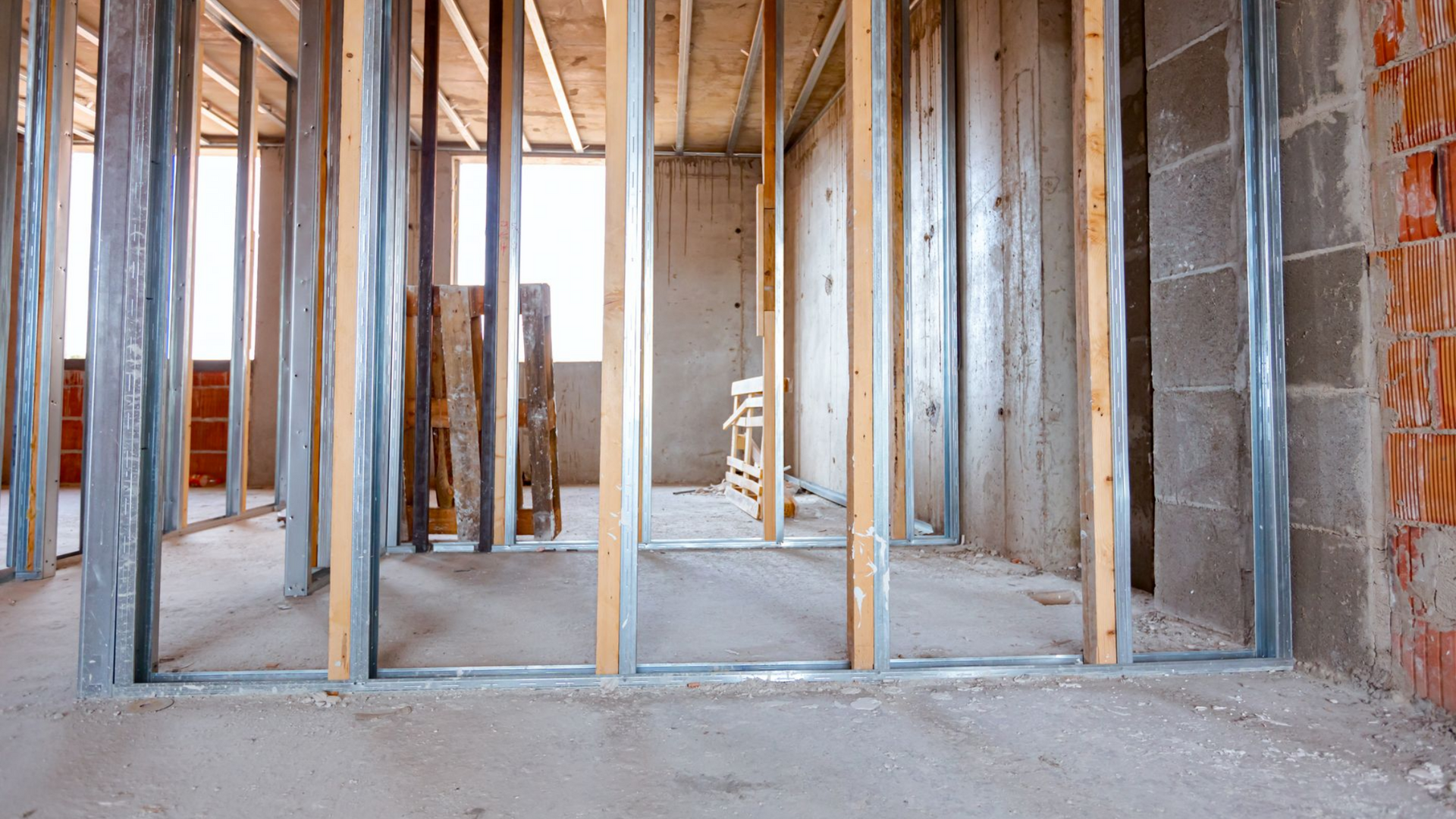 Vue intérieure d'un bâtiment en construction montrant des montants muraux en métal de cloisons.