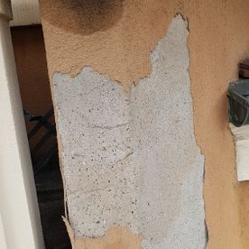 Ein Stück Beton löst sich von einer Wand.