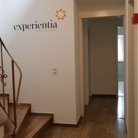 Ein Flur mit Treppen und einem Schild an der Wand mit der Aufschrift „Erlebnisreich“.