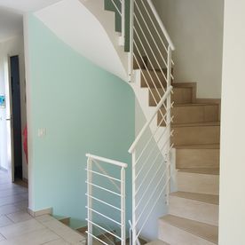 Eine Treppe in einem Haus mit einem weißen Geländer