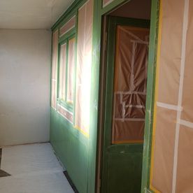 Ein Raum mit grünen Wänden und einer Tür, die gestrichen wird.