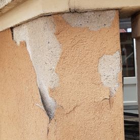 Eine Nahaufnahme einer rissigen Wand an einem Gebäude.