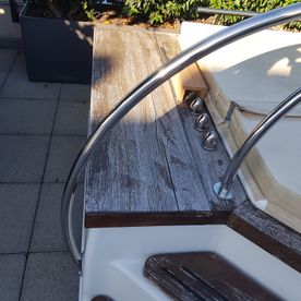 Ein Boot mit einem Holzdeck und einem Metallgeländer