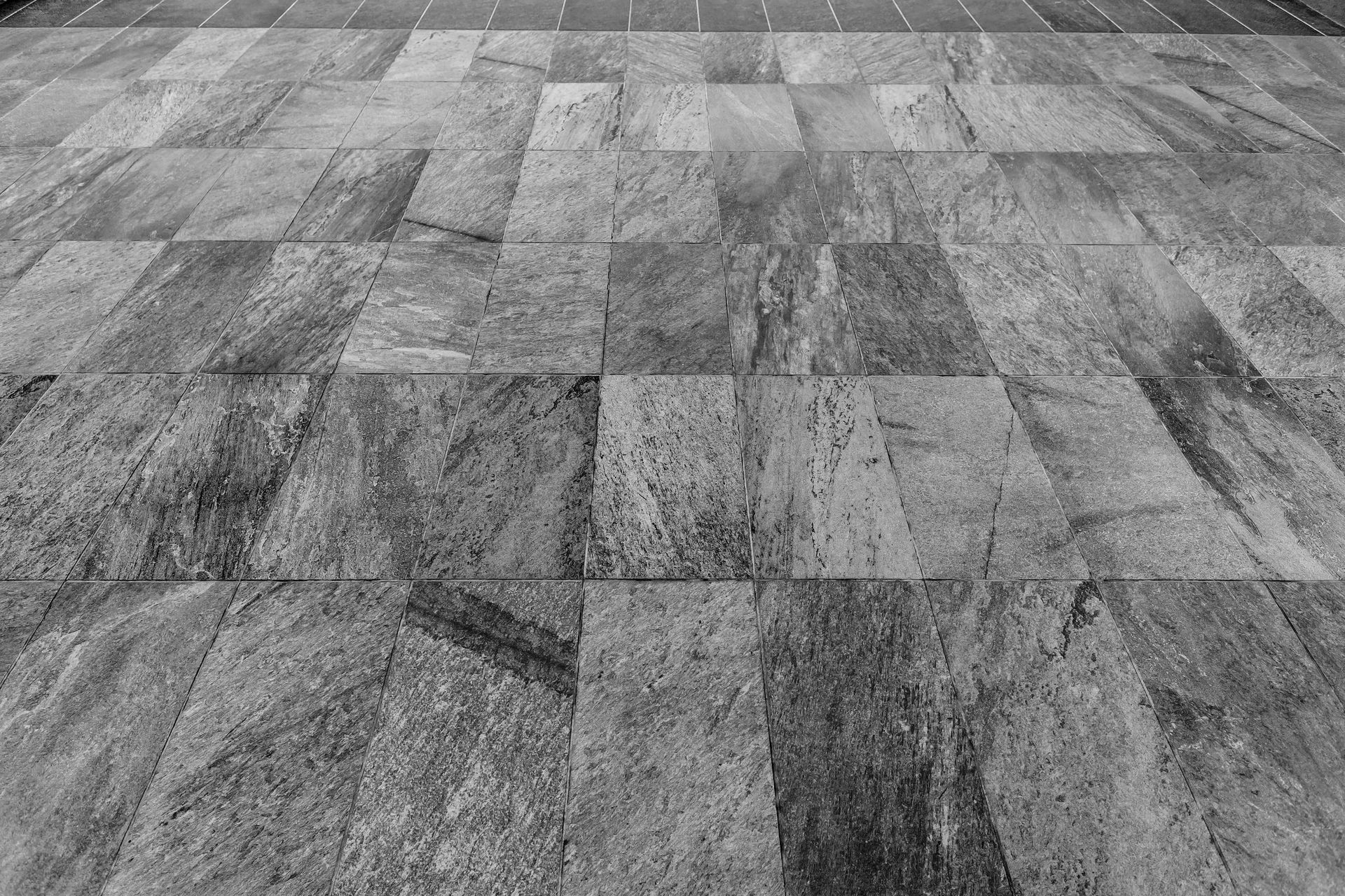 Sol carrelé gris ou pavé à motif de pierre texturée.