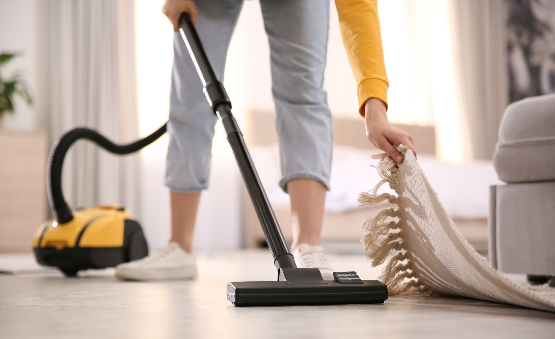 Personne en train de passer l'aspirateur sur un sol en parquet