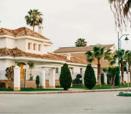 Una hilera de casas con palmeras delante de ellas en una zona residencial.