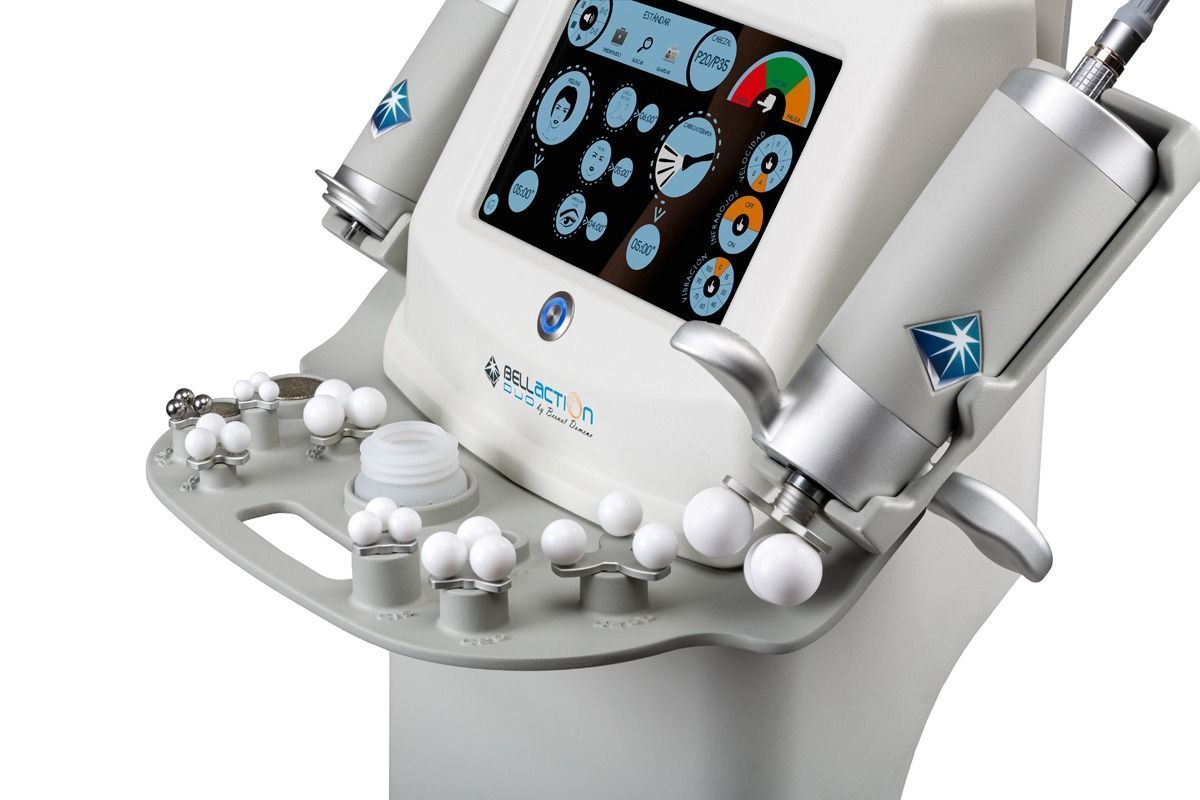 Un dispositivo médico blanco con una pantalla táctil, aplicadores adjuntos y varios cabezales de tratamiento.