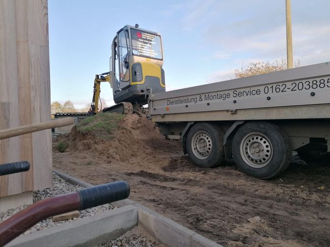 Ein Abschleppwagen transportiert auf seiner Ladefläche einen kleinen Bagger.