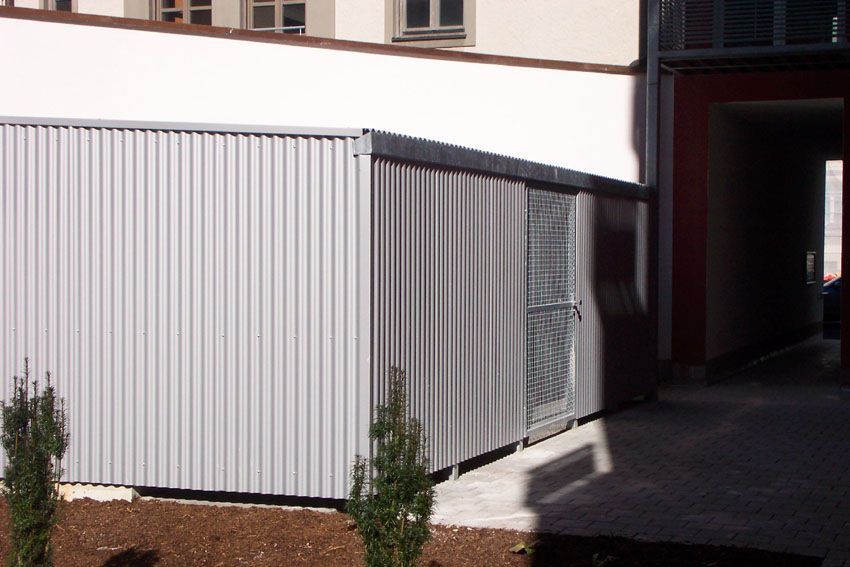 Ein weißes Gebäude mit einem Metallzaun darum