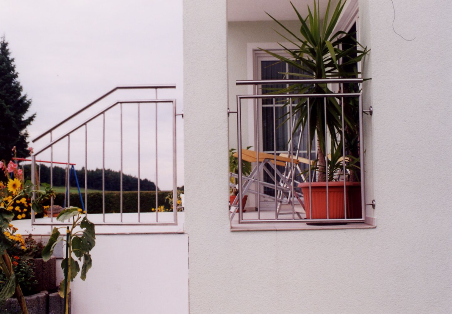 Ein Balkon mit Edelstahlgeländer und Topfpflanzen