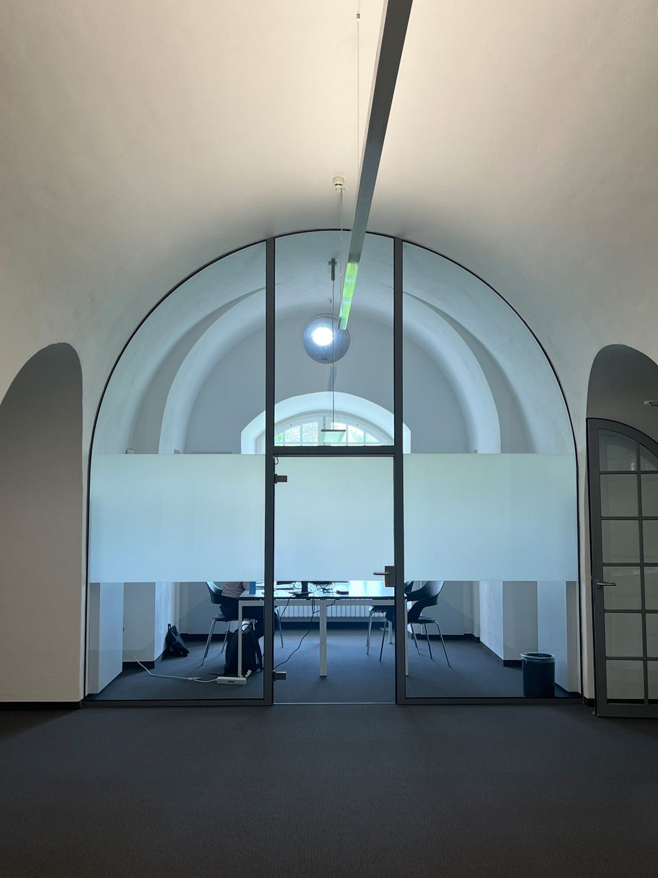 Ein Raum mit einer Glaswand und gewölbter Decke