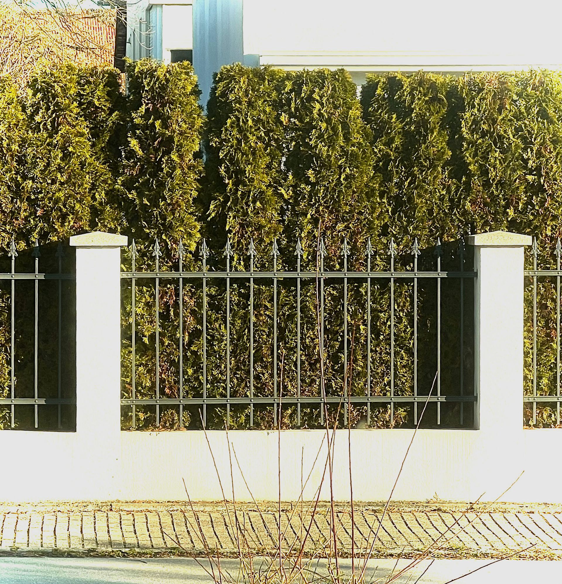 Eine weiße Wand, umgeben von einem Metallzaun
